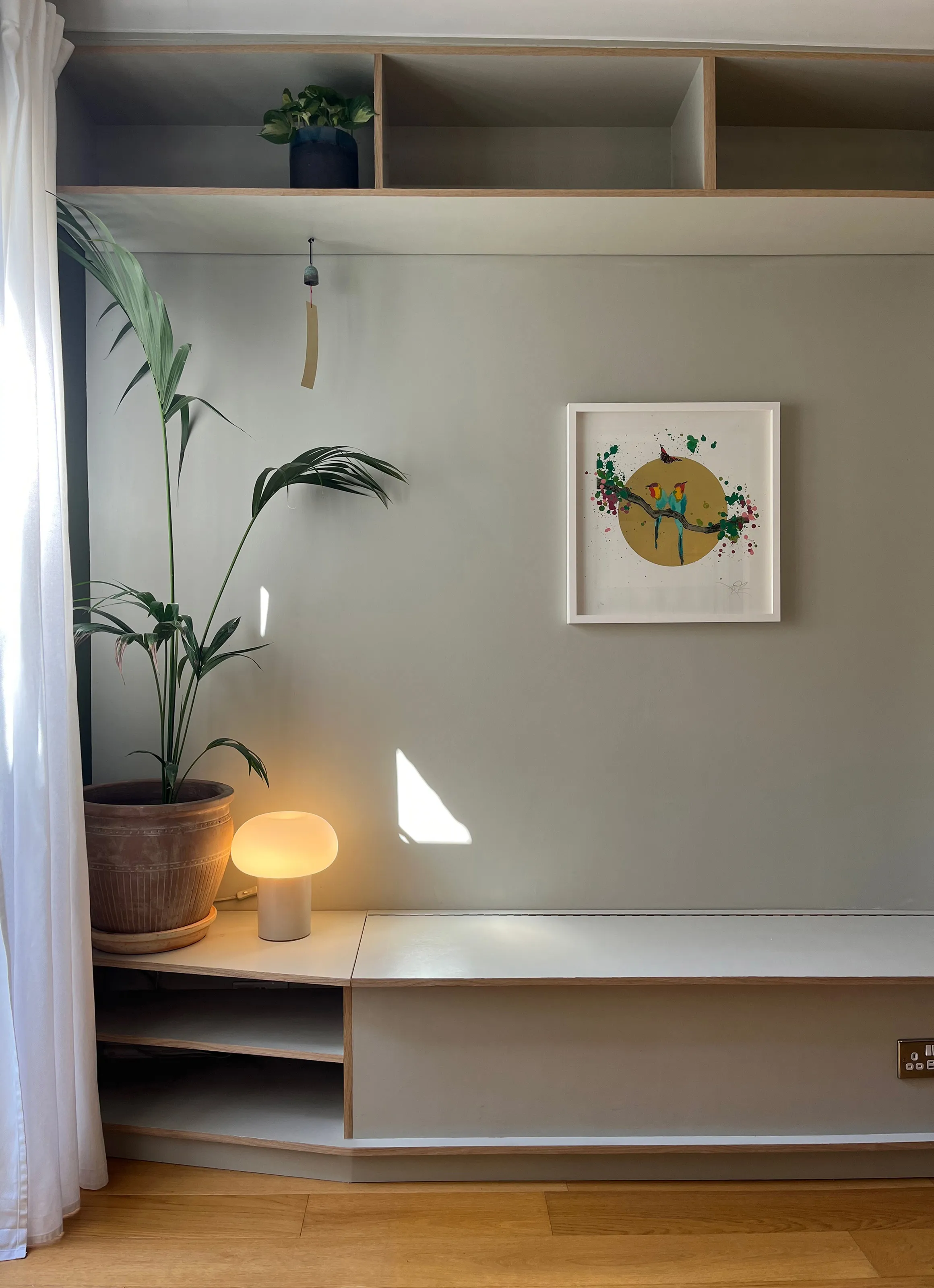 Built-in banquette bench with open storage cubbies below and matching overhead display shelves