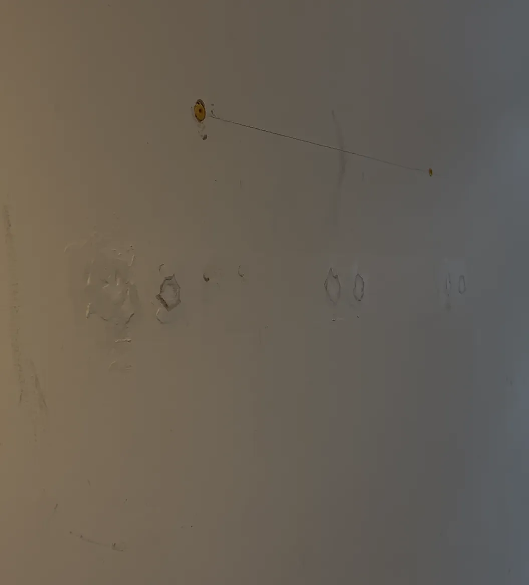 Unfinished hallway wall with wall plugs, markings, poor filler, and damage prior to panelling renovation