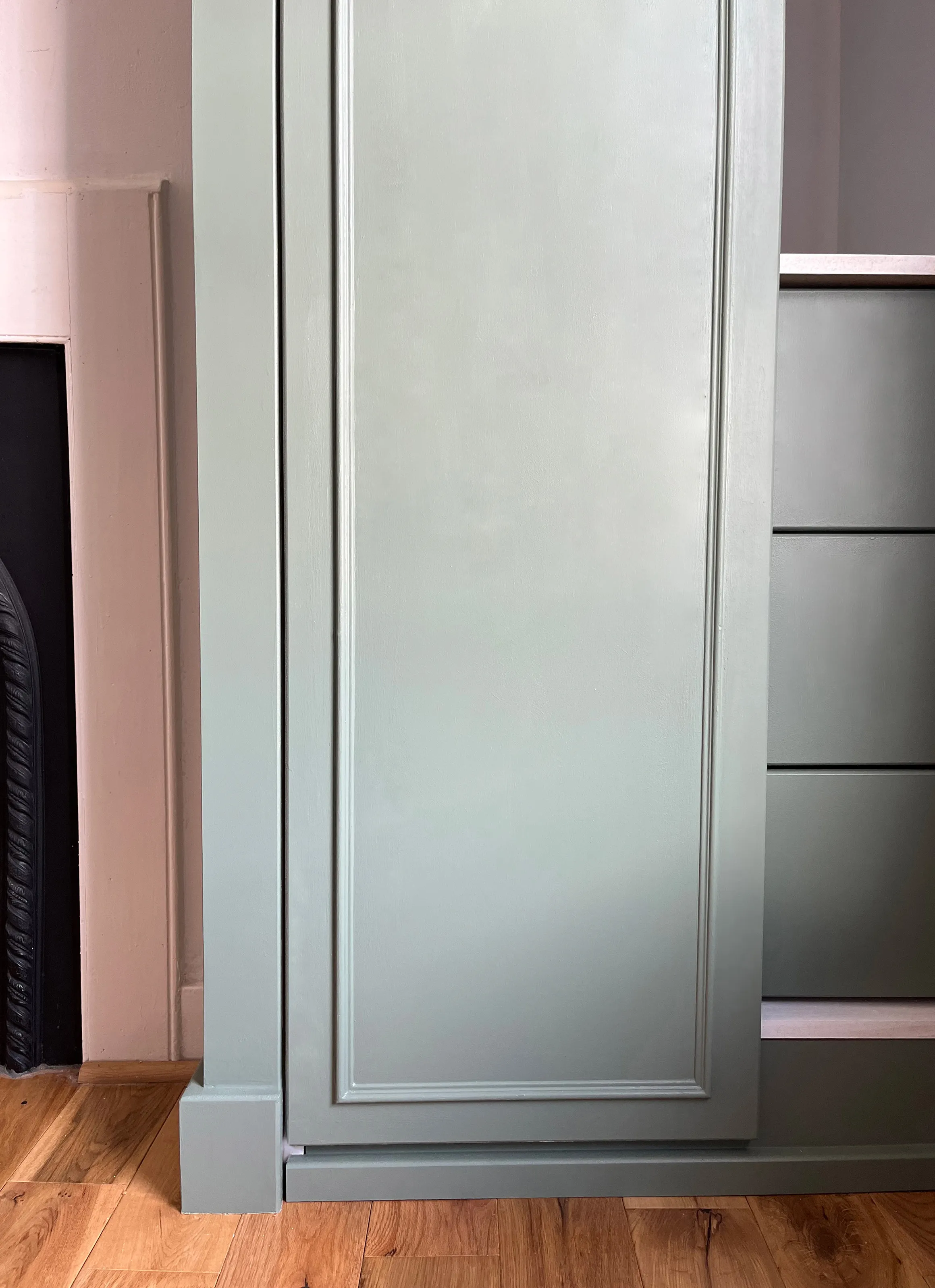 A close up of the right hand wardrobe showing the door detailing and the smaller door open showing the three green drawers inside